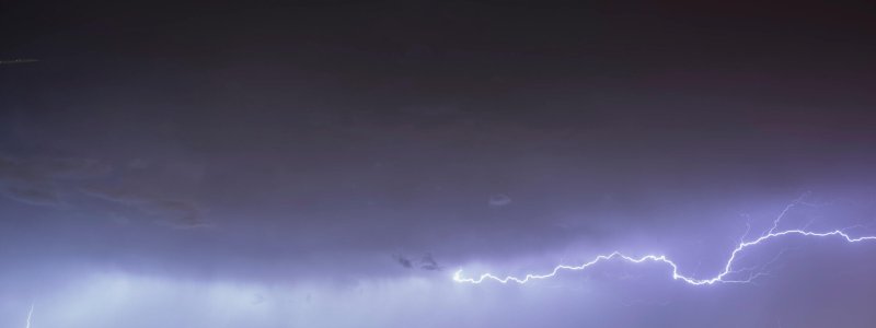 A spectacular night storm dominates the sky, marked by significant lightning. A spectacular night storm dominates the sky, marked by significant lightning, while on the horizon the lights of the big cities illuminate.
